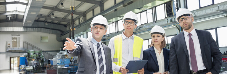Businessman discussing with colleagues in metal industry ifaa Zahlen Daten Fakten Kleine Fuehrungsspannen